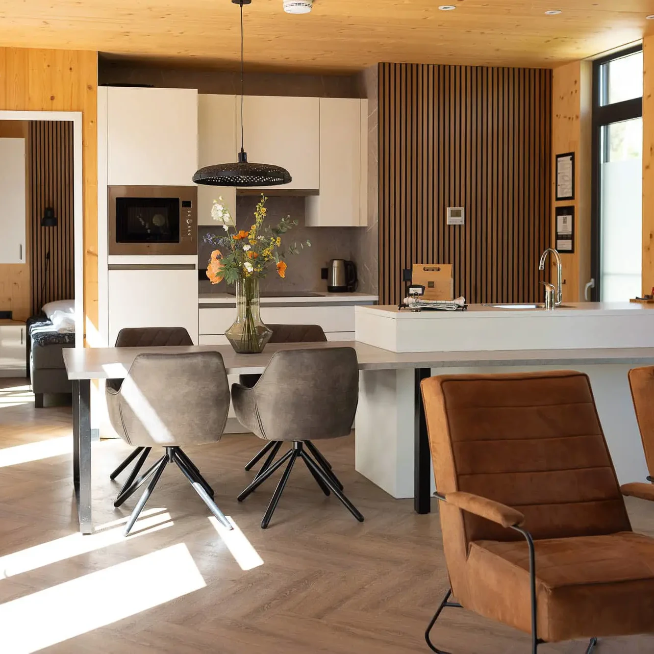Luxe woonkamer met eethoek en moderne keuken in Panorama Lodge Markelo met warme houten afwerking