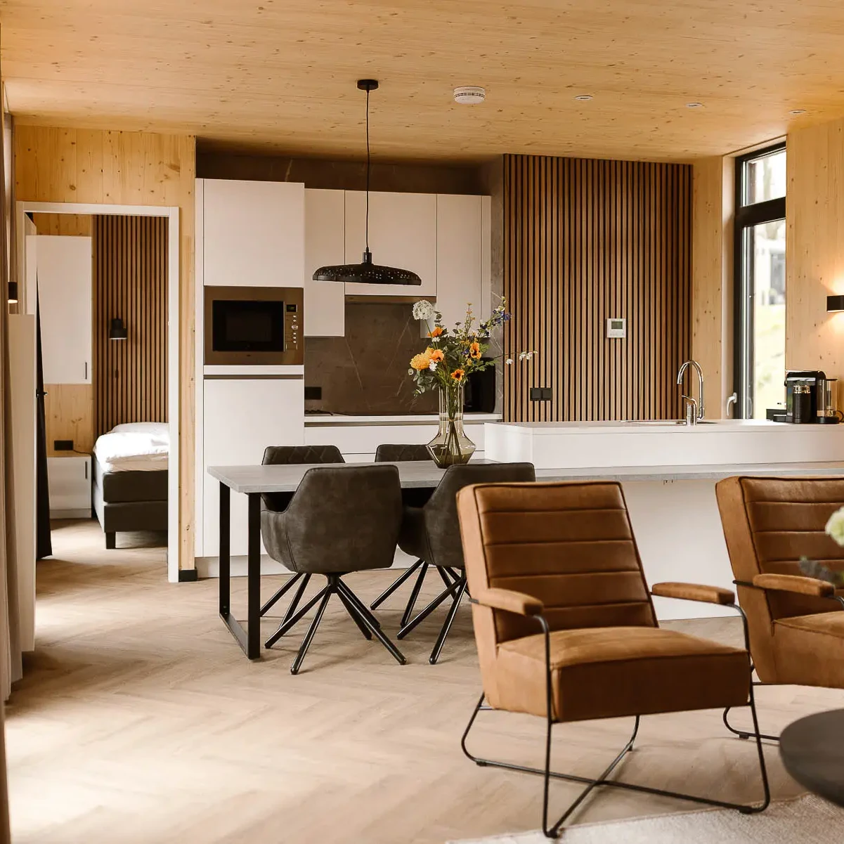 Luxe woonkamer met open keuken in Panorama lodge Zicht op Twente Markelo met houten afwerking